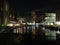 the lock entrance and moorings at clarence dock in leeds at night with buildings of the development reflected in the water and