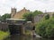 Lock gates on the canal in sowerby bridge in west yorkshire with the historic christ church building surrounded by trees