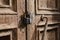 The lock on the old wooden door closeup. Rust on the metal lock. Peeling brown paint on the old door. Ancient texture