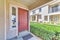 Lockbox on closed and secured brown wooden front door of a house with sidelight