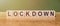 Lockdown word written on wooden blocks on wooden table. Concept for your design