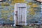 A locked barn board door on a stone building