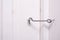 A locked metal door hook on white wooden door, simple device for home house safety and protection