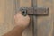 Locked vintage wooden door with hand