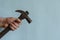 Locksmith`s hand holds a vintage hammer with a claw hammer