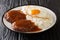 Loco moco is a Hawaiian cuisine made with white rice with a hamburger patty, sunny side up egg, and brown beef gravy close-up on a