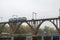 Locomotive moves along railroad arch bridge