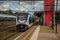 Locomotive stop on train station platform, railroad rails and blue cloudy sky at Weesp.