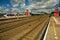 Locomotive stop on train station platform, railroad rails and blue cloudy sky at Weesp.