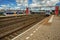 Locomotive stop on train station platform, railroad rails and blue cloudy sky at Weesp.