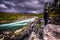 Lofoten Islands - June 16, 2018: Traveler looking at a wild stream passing through the forest in the Lofoten Islands, Norway