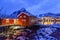 Lofoten islands, Norway. Traditional red rorbu houses, fishing village and snowy mountains in the background.