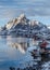 Lofoten Islands, Norway. Winter mountains and fjord with rorbu- typical red fishing lodge, reflection in water. Blue hour.