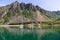 In the Lofoten Islands, sailboats drift by a remote farmstead with its characteristic red Rorbu