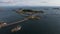 Lofoten's Tranquil Gem: A Backward Aerial Shot Showcasing Henningsvaer Harbor on a Calm Sunny Day