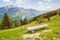 Log bench on a slope of a mountain with a beautiful view of alpine lake and landscape