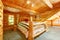 Log cabin bedroom under wood large ceiling.