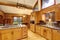 Log cabin kitchen interior design with honey color cabinets.