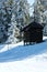 Log cabin, shelter is among snow covered pines in the winter mountains.