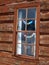 Log cabin window with small prayer flags