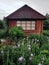 Log house in cottage garden with iris flowers