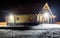 Log house on a winter evening on a slightly snow-covered building plot