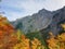 Logar valley - mountains Kamnik Alps and autumn trees in Slovenia under blue sky