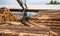 Logging, sawmill. Manipulator for loading wood. The loader of boards and logs works against the background of a stormy sky