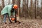 Logging, Worker in a protective suit with a chainsaw sawing wood. Cutting down trees, forest destruction. The concept of