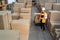 Logistic warehouse worker delivering boxes on a trolley.