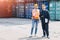 Logistic worker man and woman working team with radio control loading containers at port cargo to trucks for export and import