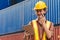 The logistics female staff is standing in front of colorful containers at habour warehouse and talking on phone. Supply chain and