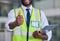 Logistics, thumbs up and clipboard for engineering, construction or architecture with black man doing inspection and