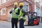 Logistics worker with tablet pc and forklift