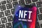 Logo close-up, non-fungible token NFT is a type of cryptorurrency which represents something unique