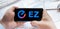 Logo of EZ coin in tablet. Cryptocurrency Easyfi token. Trading blockchain platform to buy,sell on decentralized exchange DEX,DEFI