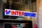The logo of Intersport clothing retail shop above an entrance with sale posters