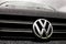 Logo of the Volkswagen automotive company on a black Transporter van