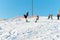 Logoisk. Belarus. 01.03.2023. A group of children snowboarders with a coach descend from a snow-covered mountain