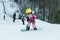 Logoisk. Belarus. 01.07.2023. A teenage snowboarder descends the slope of a snow-covered mountain in special equipment.