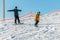 Logoisk. Belarus. 01.09.2023. A teenage snowboarder with a coach descends the slope of a snow-covered mountain