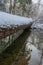 Logs covered with snow in the winter forest above the rive