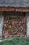 Logs of firewood stored under the stone shed