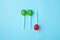 Lolli pop flat lay minimal concept, three round lolli pops are luing on blue background, trendy pop art style photo, isolated.