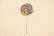 Lollipop swirl on wooden stick on beige paper