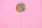 Lollipop swirl on wooden stick on pink paper