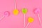 Lollipops of yellow, pink, green colors on wooden stick in the shape of circle, heart, flower.