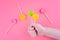 Lollipops of yellow, pink, green colors on wooden stick in the shape of circle, heart, flower.