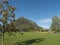 Lom, Norway, September 8, 2019: vew on houses of village Lom with geen grass, hills and rowan tree. Early autumn, sunny