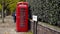 London, Britain-September, 2019: Red telephone booth on street with trees and people. Action. Red public telephone booth